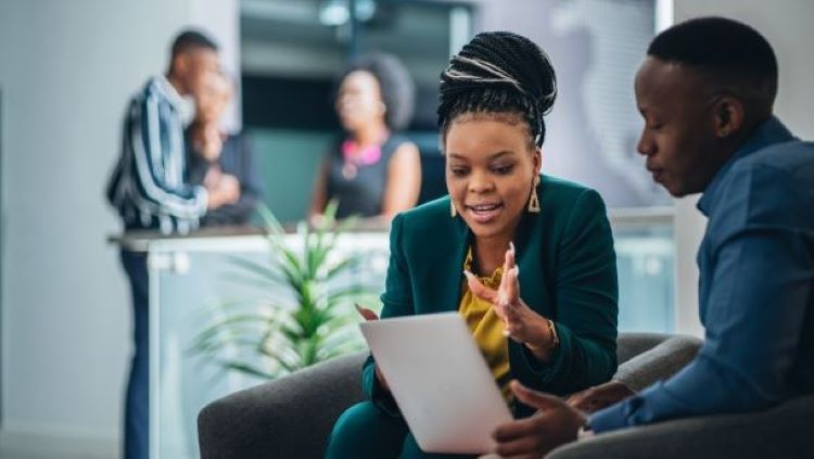 two people sat talking at a laptop